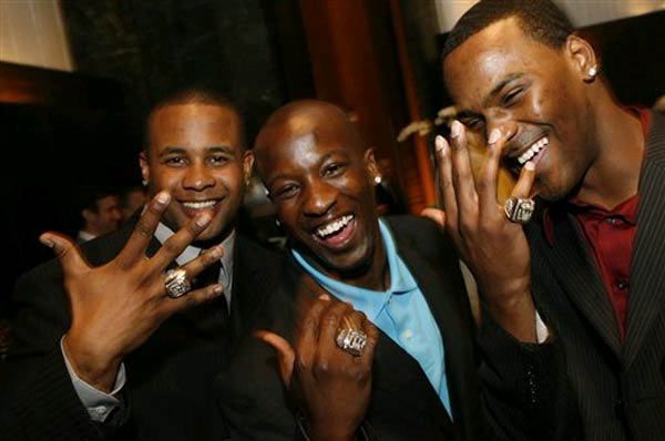 New York Giants running back Derrick Ward, left, cornerback Kevin Dockery, center, and cornerback Aaron Ross show off their rings.